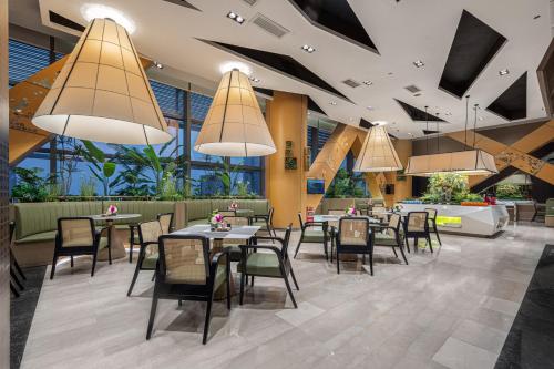 a restaurant with tables and chairs and large windows at 佛山南海金融城瑾程酒店 in Nanhai
