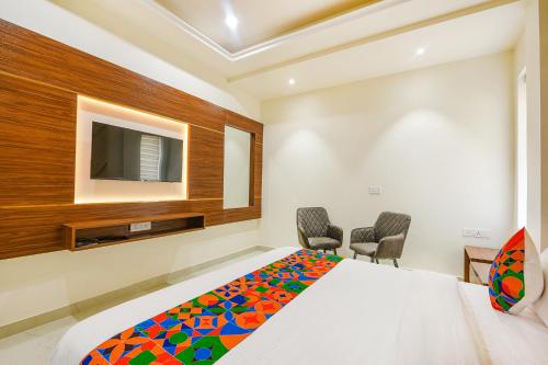 a bedroom with a bed and a tv on the wall at FabHotel K9 Royal in Ludhiana