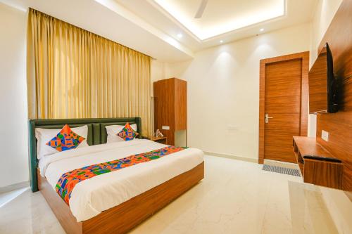 a bedroom with a large bed and a television at FabHotel K9 Royal in Ludhiana