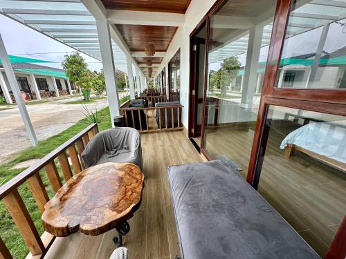 a porch with a table and a bed and a table at Myhoa Lagoon - Kiting Town in Phan Rang