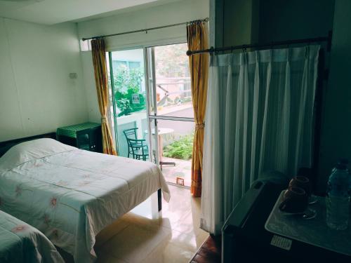 Schlafzimmer mit einem Bett und einem Fenster mit einem Balkon in der Unterkunft Nu Phuket Airport Resident 1 in Nai Yang Beach