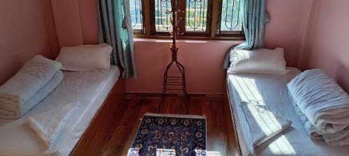 two beds in a room with a window at Sunshine homestay in Tānsing