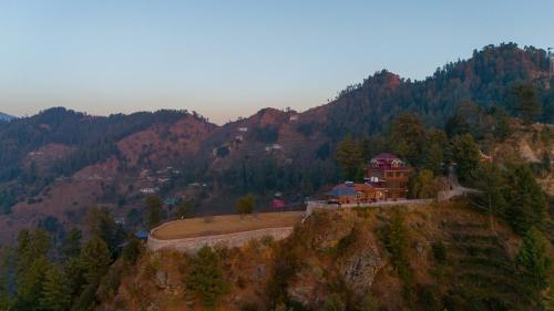 a house on the side of a mountain at Alaya Stays Lafu Woodscave Room with Attic & Hill views in Shimla
