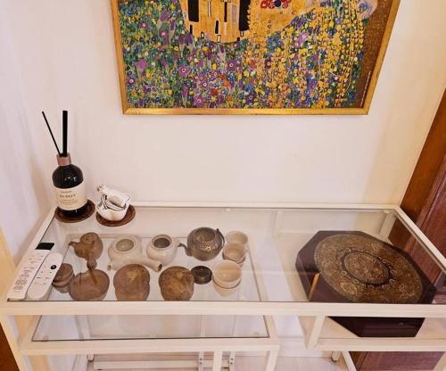 a shelf with a painting on the wall with artifacts at The best trip of my life at Suwon Haenggung, 4 people, Changnyongmun, relaxation, love stay, essence of Airbnb, beam TV, healing and love stay in Suwon