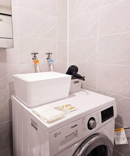 a washing machine with a sink on top of it at The best trip of my life at Suwon Haenggung, 4 people, Changnyongmun, relaxation, love stay, essence of Airbnb, beam TV, healing and love stay in Suwon