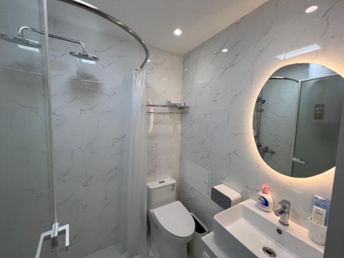 a bathroom with a toilet and a sink and a mirror at Tonight Homestay South Shanxi Road Shanghai in Shanghai