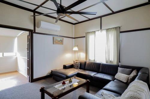 a living room with a couch and a ceiling fan at Cosy 3-Bed Home with Fireplace & Outdoor BBQ in Tenterfield