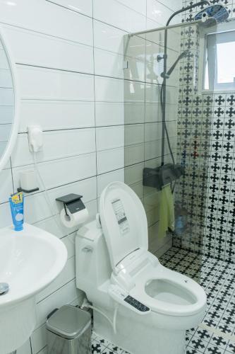 a white bathroom with a toilet and a shower at The Stay Christmas Yusuam in Jeju