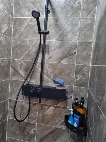 a shower with a shower head in a bathroom at The Stay Christmas Yusuam in Jeju