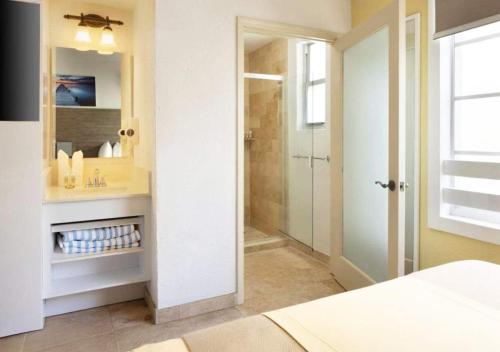 a bathroom with a shower and a sink and a mirror at Ocean Drive Suite in South Beach Family & Pet Friendly in Miami Beach