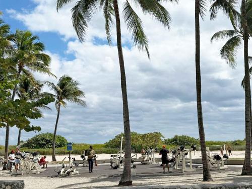 a group of people walking around a park with palm trees at Ocean Drive Suite in South Beach Family & Pet Friendly in Miami Beach