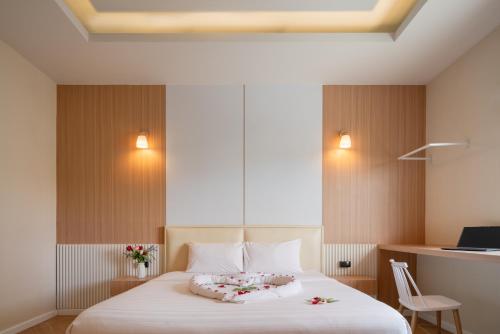 a bedroom with a white bed with flowers on it at Grandbangsaray in Na Jomtien