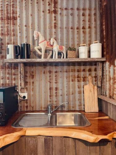 a kitchen sink with two toy horses on a shelf at Charming 1-Bed Farm Cabin with Wood Fire in Tenterfield