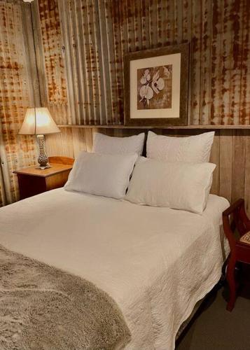 a bed with white sheets and pillows in a bedroom at Charming 1-Bed Farm Cabin with Wood Fire in Tenterfield