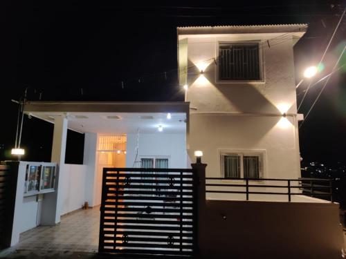 a house with a balcony at night with lights at Sai Premasharanalaya Kotagiri in Kotagiri