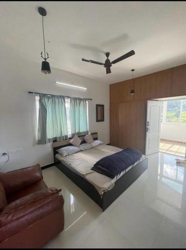 a bedroom with a bed and a ceiling fan at Sai Premasharanalaya Kotagiri in Kotagiri