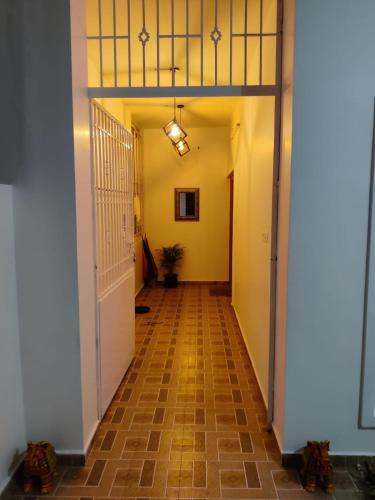 a hallway with yellow walls and a white door at Sai Premasharanalaya Kotagiri in Kotagiri