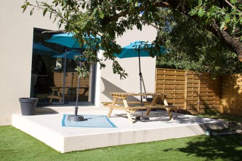 a patio with a bench and an umbrella at Villa familiale Luberon 3ch calme jardin parking in Saignon