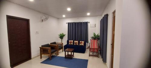 sala de estar con silla azul y puerta en Dalevista, en Idukki