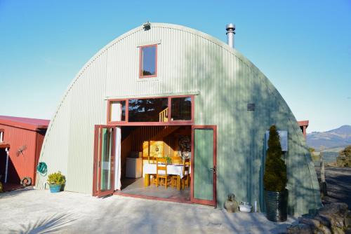 a large white dome house with a dining room in it at Barn Bed and Breakfast in Waitati