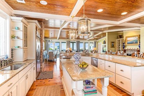a large kitchen with white cabinets and wooden ceilings at Tenth Street Retreat in Tybee Island