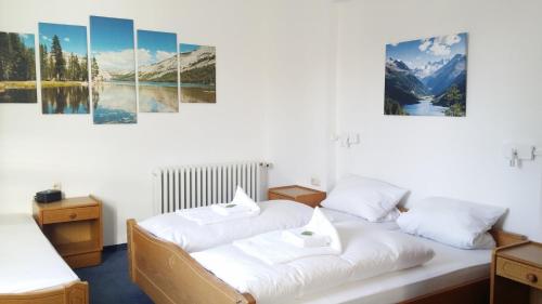 two beds in a room with mountains and water at Hotel Hasen Kaufbeuren Allgäu in Kaufbeuren