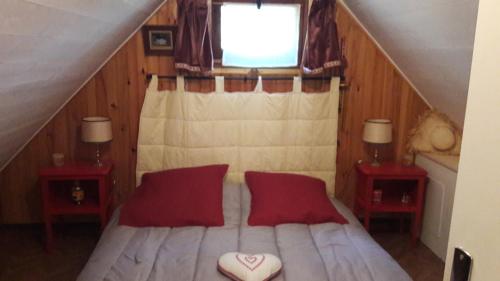 une chambre avec un lit avec des oreillers rouges et une fenêtre dans l'établissement The Chalet VertVentoux - Charming Wooden Chalet for a Cozy and Relaxing Getaway, à Bédoin