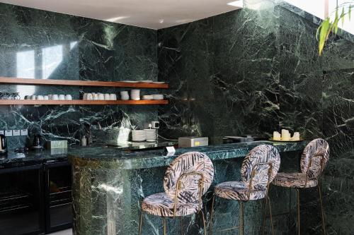 a restaurant with a black marble counter and chairs at WealthyStays 360 Luxury Residence in Nicosia