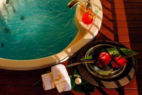 a pool with a bowl of water and a plate with flowers at Kanucha Bay Hotel & Villas in Nago