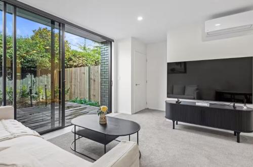 a living room with a couch and a table at Sanctuary in St Albans Chic 2-Bedroom Retreat in Christchurch