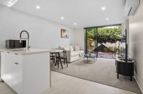 a kitchen and living room with a couch and a table at Sanctuary in St Albans Chic 2-Bedroom Retreat in Christchurch