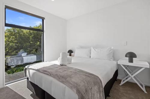 a bedroom with a large bed and a large window at Sanctuary in St Albans Chic 2-Bedroom Retreat in Christchurch