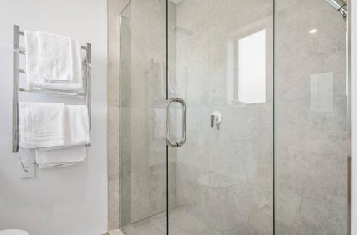 a bathroom with a shower with a glass door at Sanctuary in St Albans Chic 2-Bedroom Retreat in Christchurch