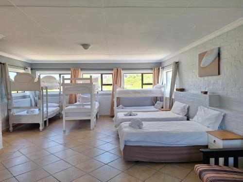 a room with two beds and a living room with a couch at Pili Pili Beach Cabanas in Sedgefield