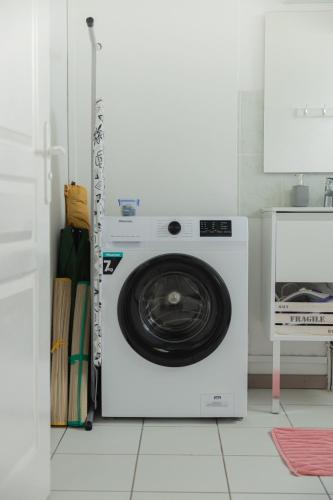 a white washing machine sitting in a kitchen at Le chant du Lagon in La Saline les Bains