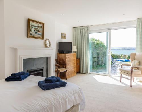 a bedroom with a bed with two blue towels on it at Carn Du 1 in Padstow