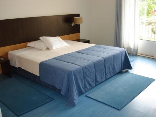 - une chambre avec un lit doté de tapis bleus au sol dans l'établissement Hotel Rural Solar Das Freiras, à Figueiró dos Vinhos