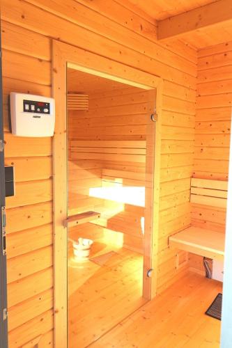 a small sauna with a bench in a wooden room at 25 Ferienwohnung Mummengarten mit Wallbox in Landkirchen