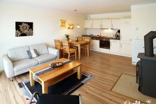 a living room with a couch and a table at 22 Ferienwohnung Fuhr An der Reiterkoppel 1 EG in Burg auf Fehmarn
