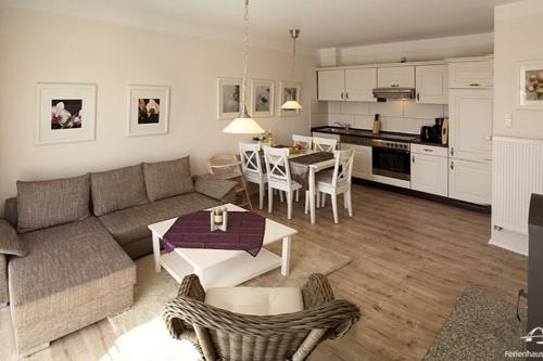 Una sala de estar y una cocina con un sofá y una mesa. en 27 Ferienwohnung an der Reiterkoppel 49a EG, en Burg auf Fehmarn