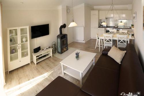 Una sala de estar con un sofá y una sala de estar con chimenea. en 28 Fehmarn An der Reiterkoppel 49b EG, en Burg auf Fehmarn