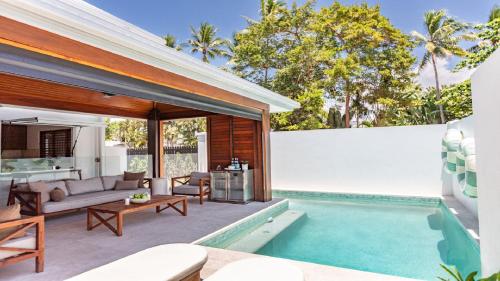 an outdoor patio with a swimming pool and a house at Villa 1 Chez Willow Port Douglas in Port Douglas