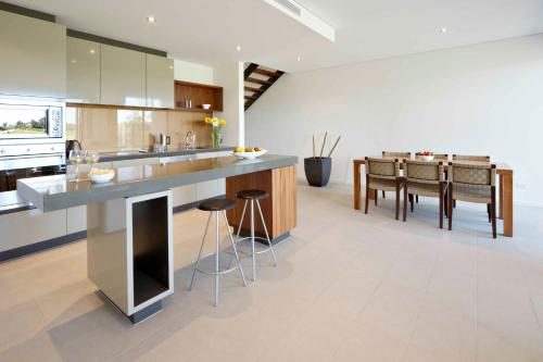 a kitchen with a large counter and a dining room at Pullman Magenta Shores Resort in The Entrance