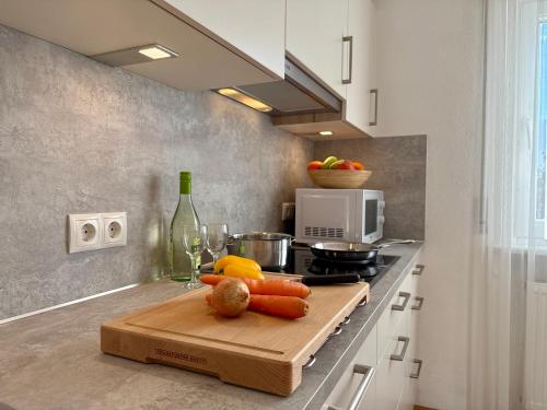 a kitchen with a cutting board with vegetables on a counter at App. Tamanhof in San Giorgio