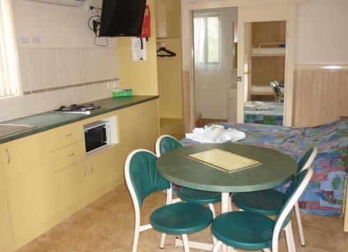 a kitchen with a table and chairs in a kitchen at Roma Big Rig Tourist Park in Roma