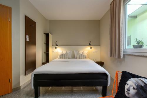 a hotel room with a bed and a window at SleepinRoomz Boutique Hotel in Dortmund