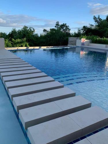 a swimming pool with steps in the water at Modern Condo, Sea View, Fast Wifi, Cafe, Panglao in Dauis