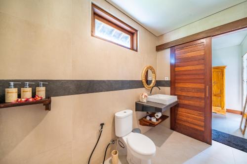 un baño con inodoro y lavabo en Villa Shanti Ceningan, en Nusa Lembongan