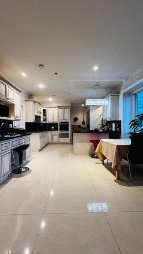 a large kitchen with white cabinets and a table at Coze home in Vancouver near YVR in Vancouver
