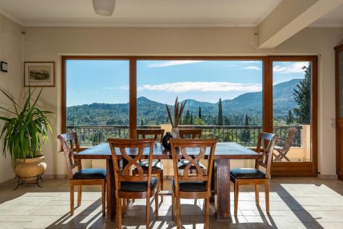 a dining room with a table and chairs and a large window at Mansion on the Hill by CorfuEscapes in Virós